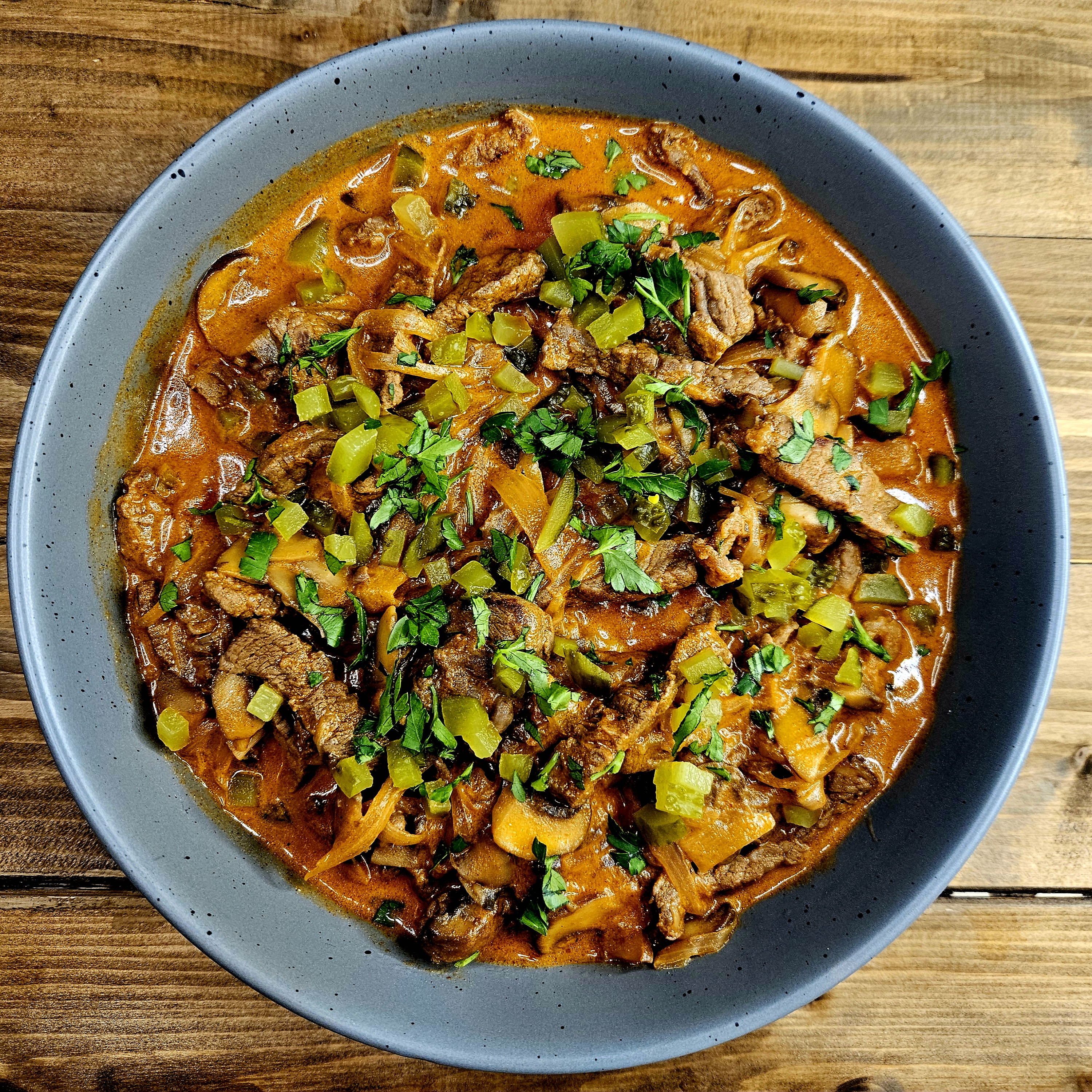 Beef Stroganoff with Sour Cream served in a bowl & topped with diced Gherkins