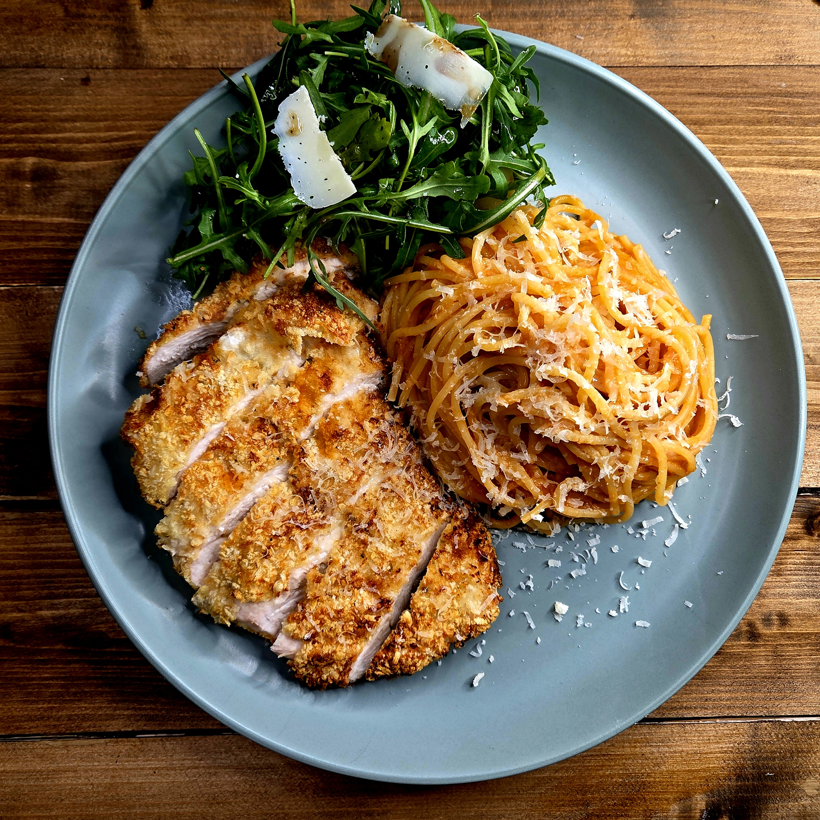 Air Fryer Pollo Milanese with breadcumbed chciken, rocket salad, tomato sauce and spagheti